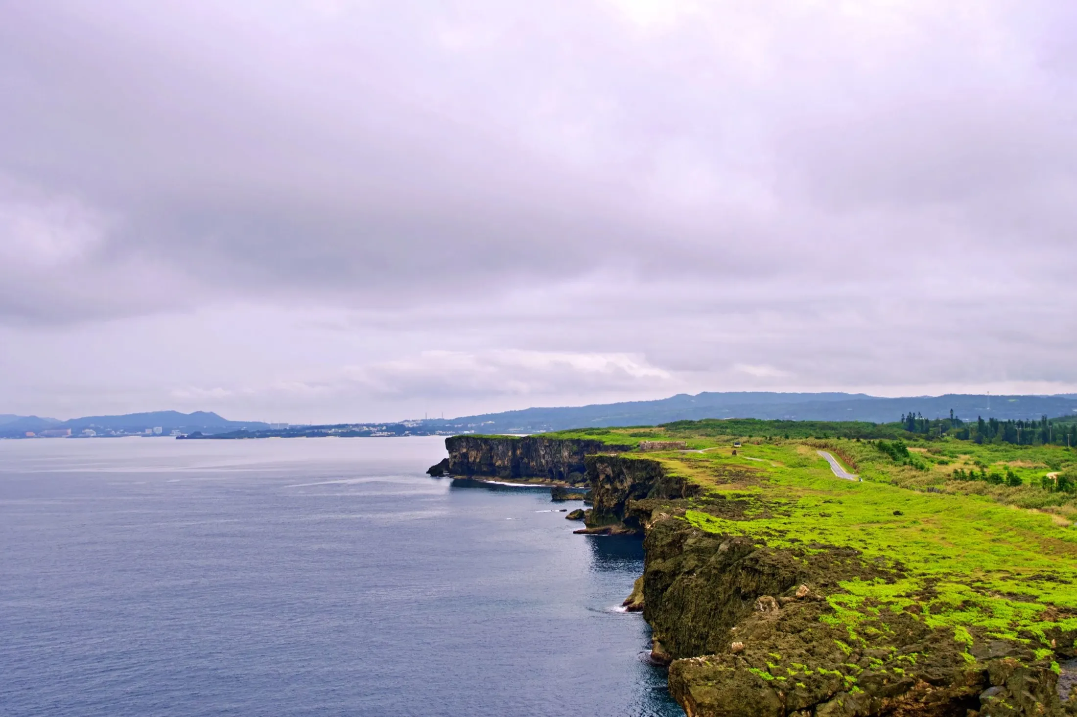 The green cliffs and quiet coastline of Okinawa